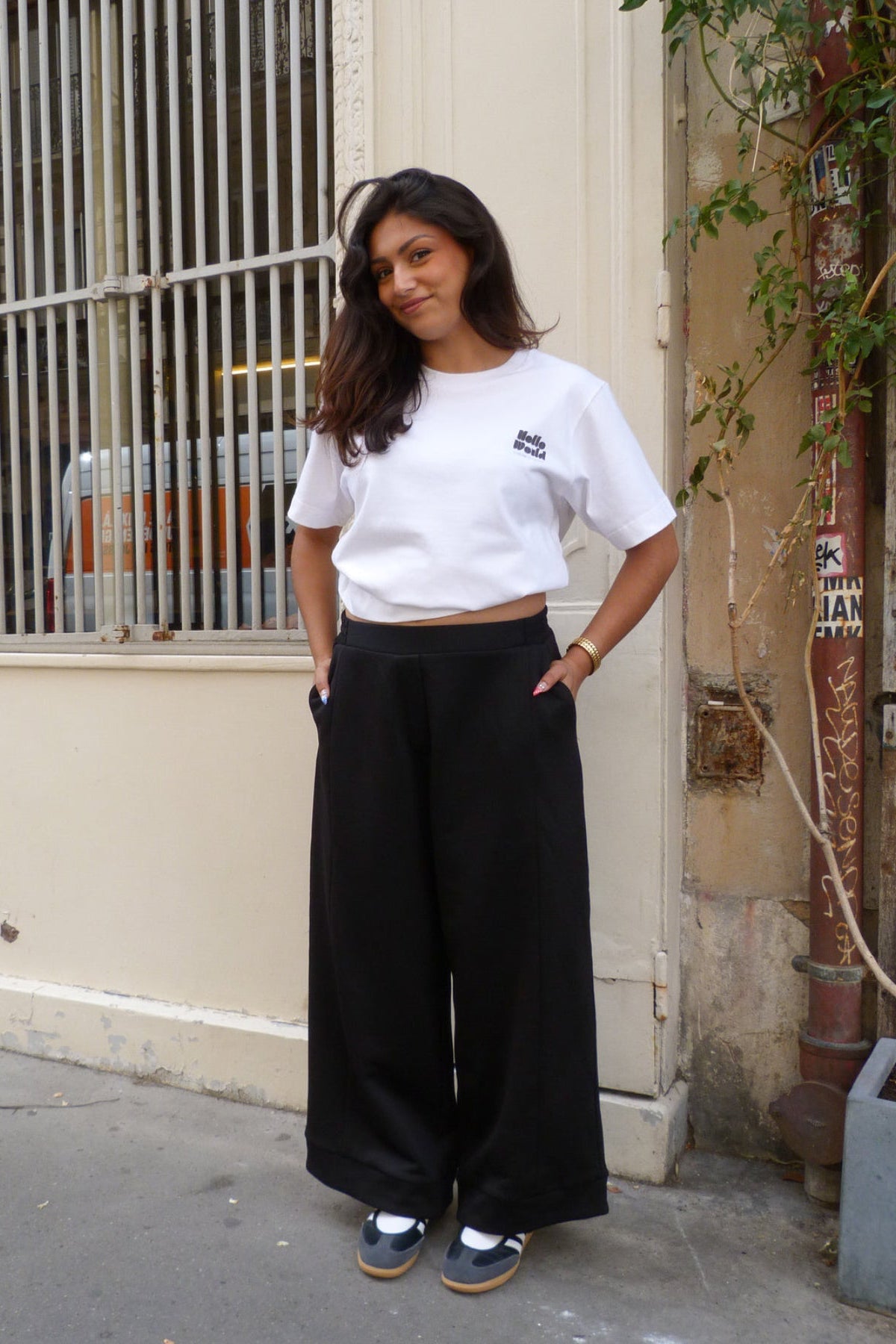 Pantalon Anna - pantalon noir large, mains dans les poches, porté en rue - Hello World Le Studio
